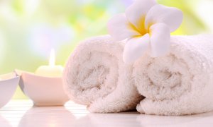 Elevation Med Spa Lone Tree Colorado white rolled towels with flower and lit candle at a spa