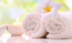 Elevation Med Spa Lone Tree Colorado - About Us two white rolled towels with flower and lit candle